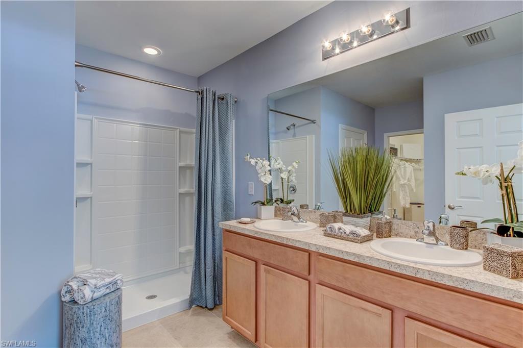 679 Hadley Place East Naples, FL 34104 - Photo 7 of 9 a bathroom with a double vanity sink and a mirror