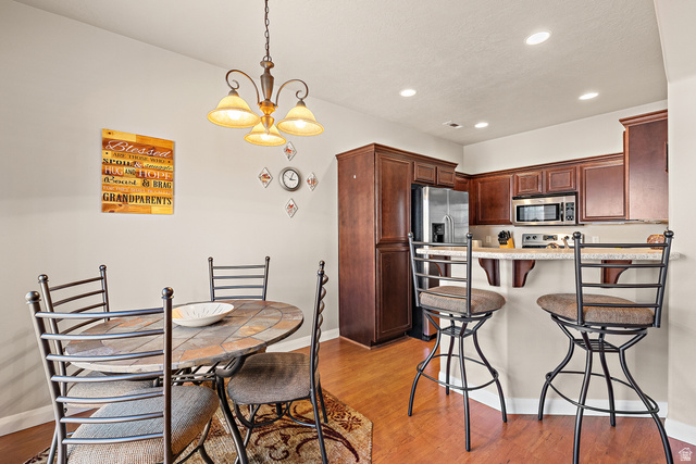 2484 Manzoni Road Santa Clara, UT 84765 - Photo 14 of 27 Kitchen with a breakfast bar, a peninsula, hanging lights, and light wood-type flooring