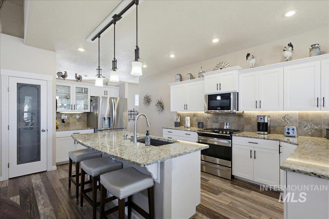 24623 Falcon Lane Caldwell, ID 83607 - Photo 8 of 40 Bright kitchen featuring a central island with a built-in sink and pendant lighting