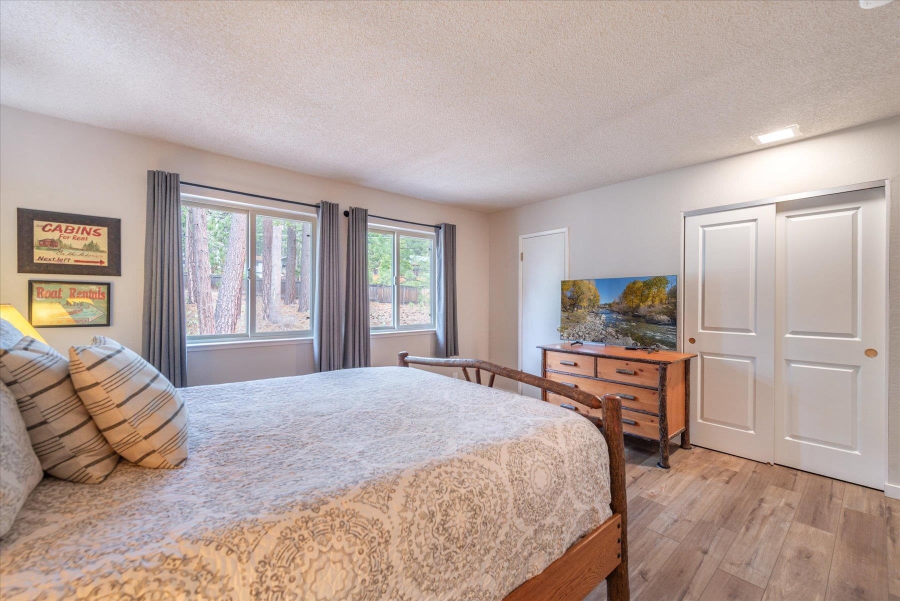 3101 Lake Forest Road, Unit 26 Tahoe City, CA 96145 - Photo 17 of 27 a bedroom with a bed and furniture with wooden floor