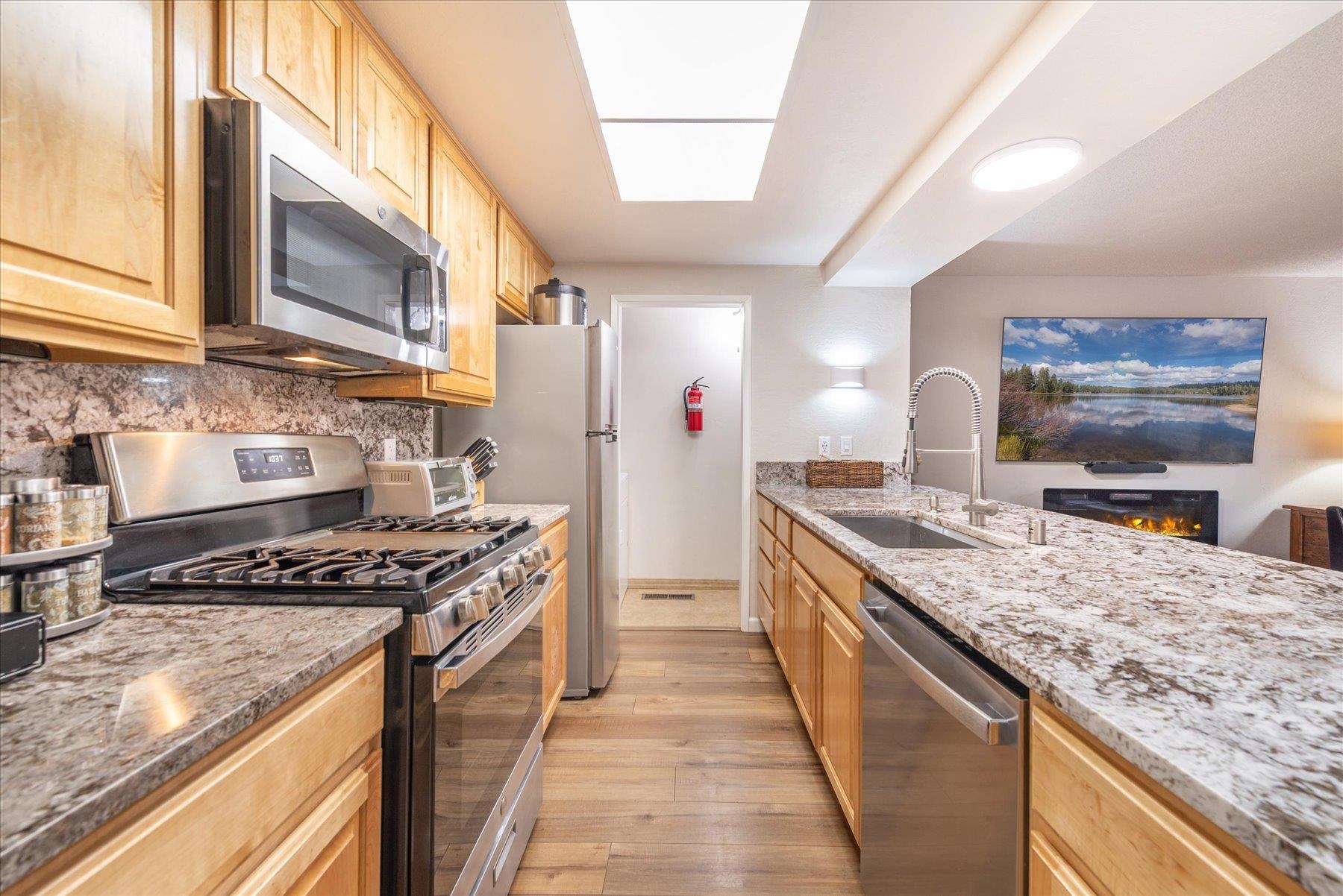 3101 Lake Forest Road, Unit 26 Tahoe City, CA 96145 - Photo 9 of 27 a kitchen with stainless steel appliances granite countertop a stove a sink and a refrigerator