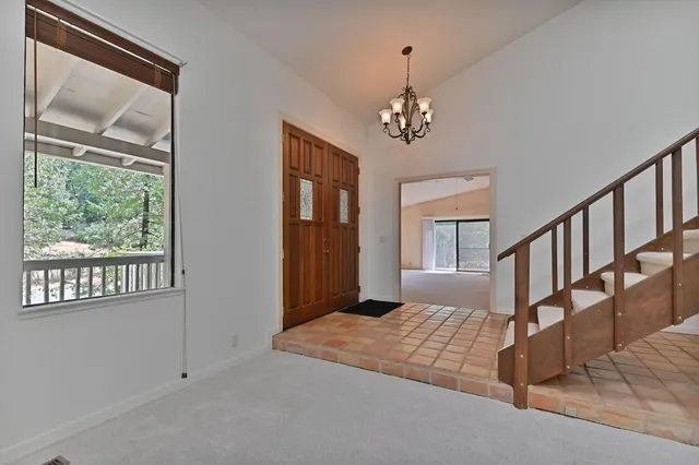 a view of an empty room with a fireplace and a window
