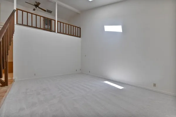 a view of a big room with windows and chandelier fan