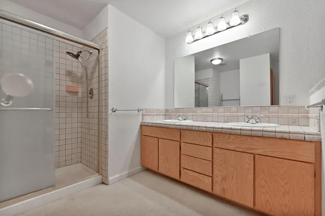 an empty room with windows and ceiling fan