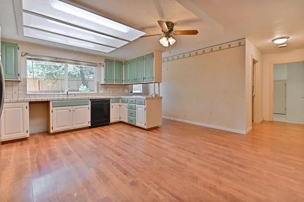 an empty room with chandelier fan