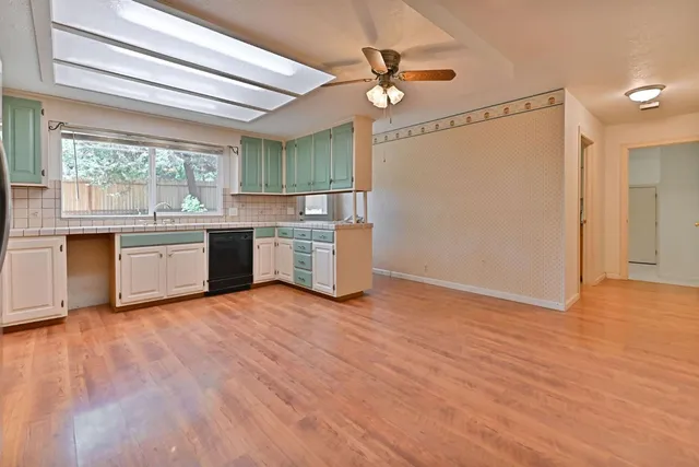 an empty room with chandelier fan
