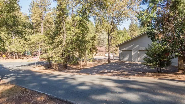 a view of a house with a yard and large tree