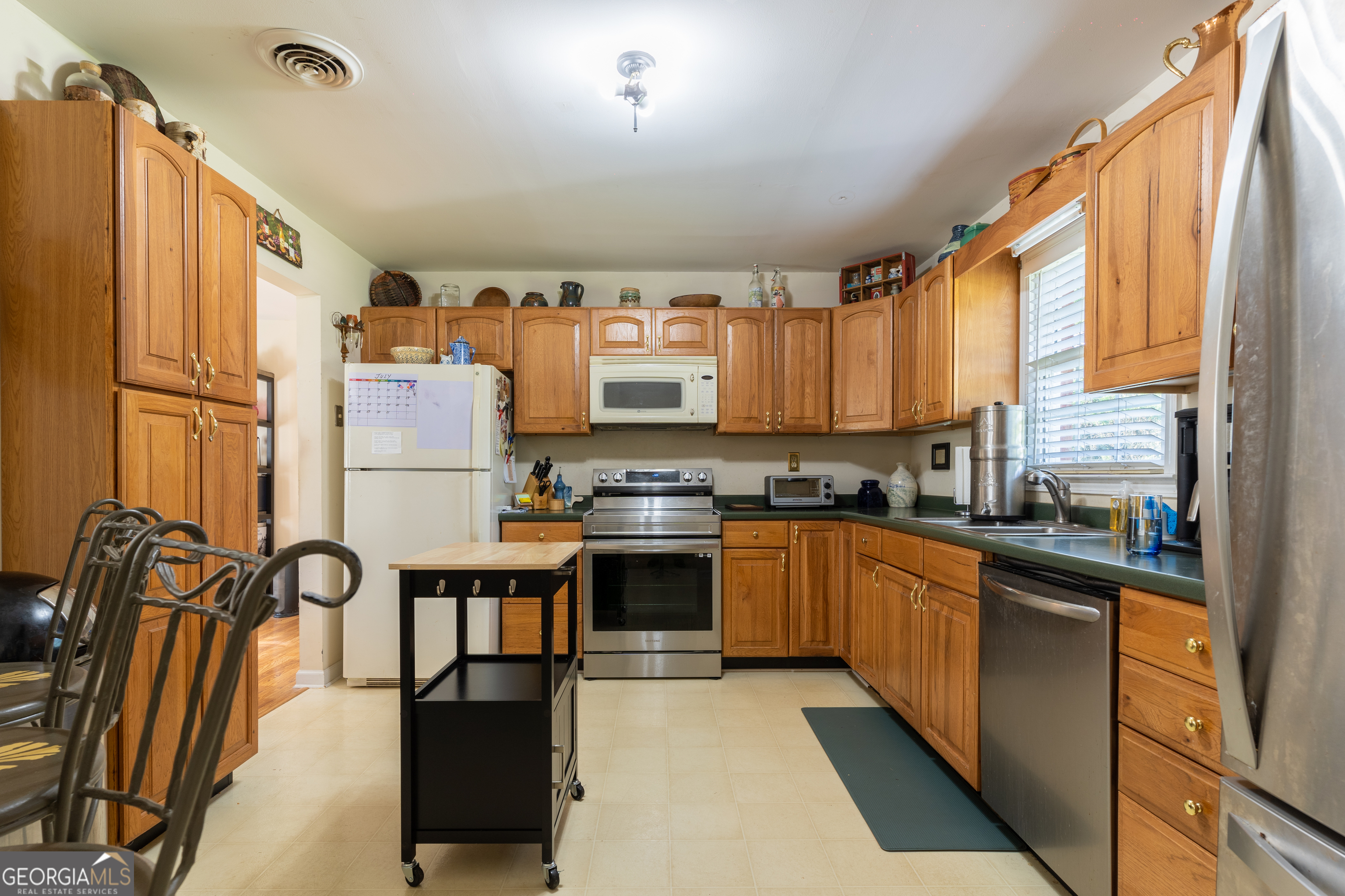 1537 Jackson Street Locust Grove, GA 30248 - Photo 16 of 41 a kitchen with granite countertop a refrigerator and a stove top oven