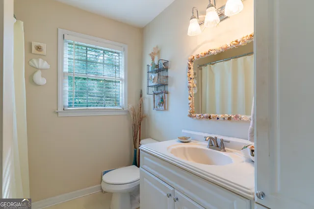 a bathroom with a sink toilet and a mirror