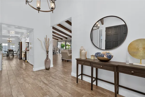 a living room with couches a table and potted plants with wooden floor