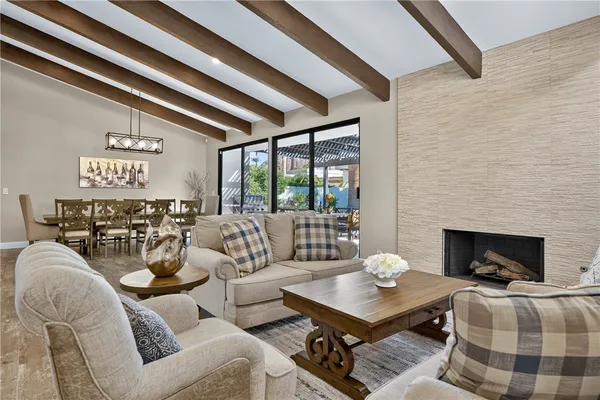 a living room with furniture a fireplace and floor to ceiling window