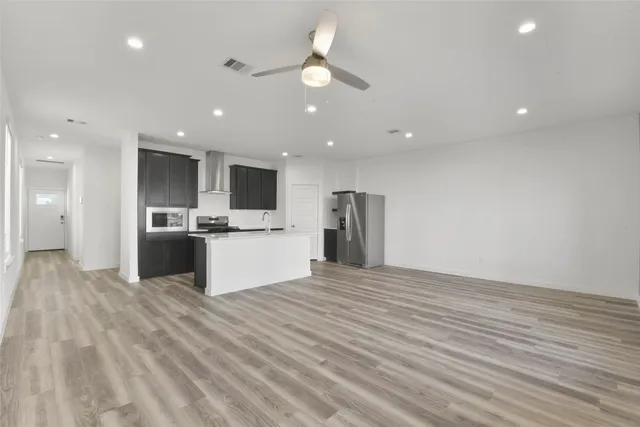 a view of kitchen with granite countertop cabinets and refrigerator