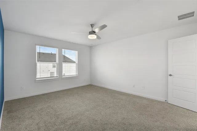 a view of an empty room with a chandelier fan