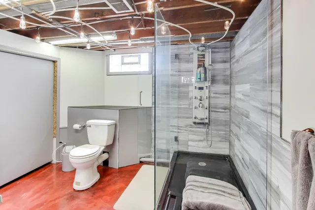 a bathroom with a toilet and a shower