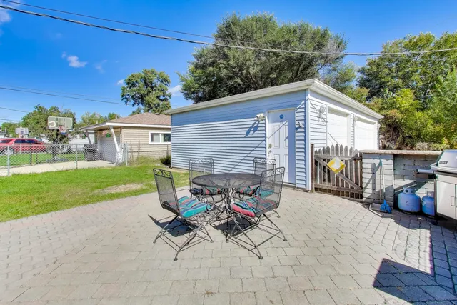 a view of a patio with a dining table and chairs with wooden fence