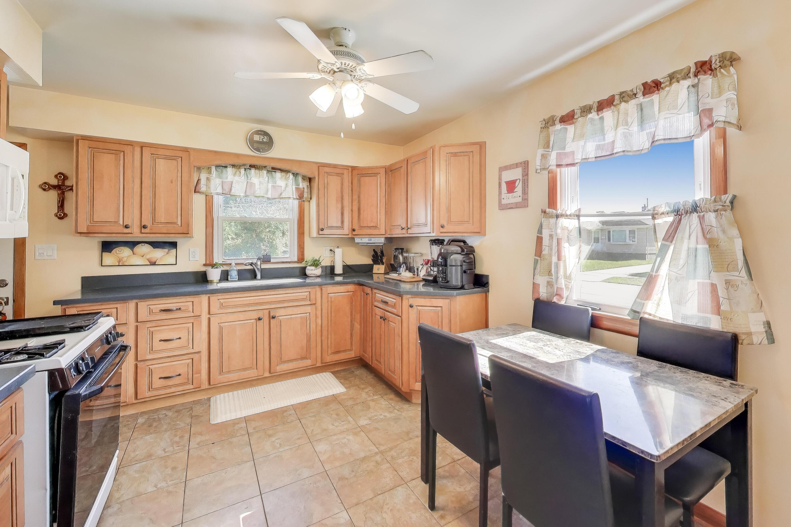 1343 Harvey Street Griffith, IN 46319 - Photo 5 of 31 a kitchen with a stove a sink a dining table and chairs