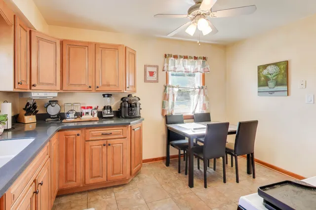 a kitchen with granite countertop a table chairs sink and cabinets