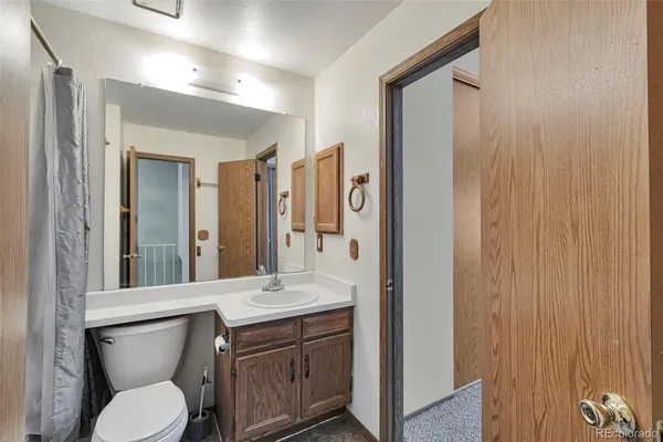 a bathroom with a granite countertop sink toilet and shower