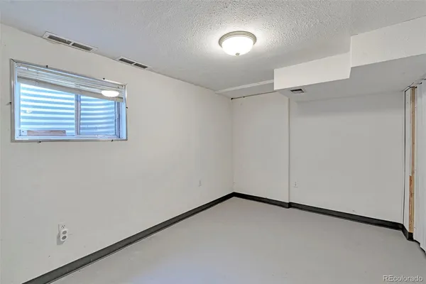 an empty room with a ceiling fan and a window