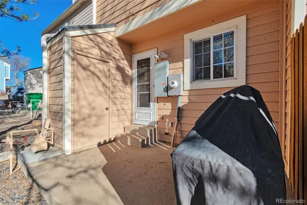 a view of balcony with a couple of cars parked in front of house