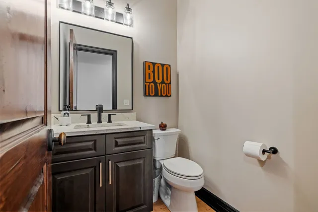 a bathroom with a toilet a sink and mirror