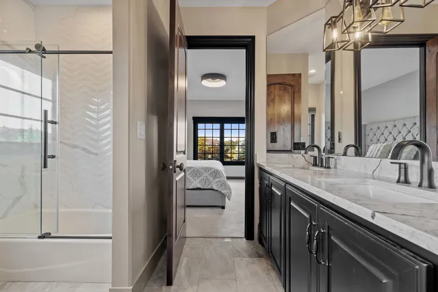 a en suite bathroom with a granite countertop sink and a mirror