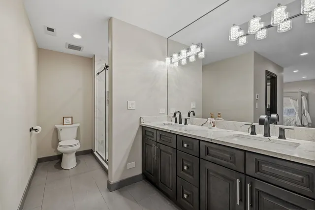 a bathroom with a double vanity sink mirror and toilet