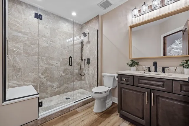 a bathroom with a bathtub shower sink mirror and toilet