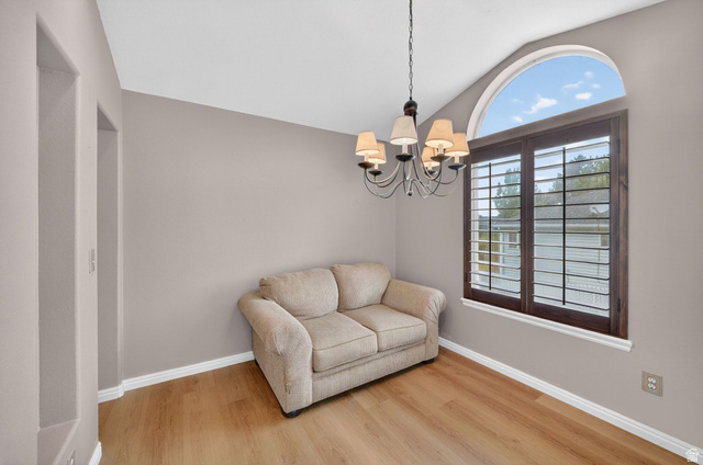1464 990 West Provo, UT 84601 - Photo 8 of 41 Room featuring wood-finish flooring, a vaulted ceiling, and a prominent arched window with dark wood plantation shutters