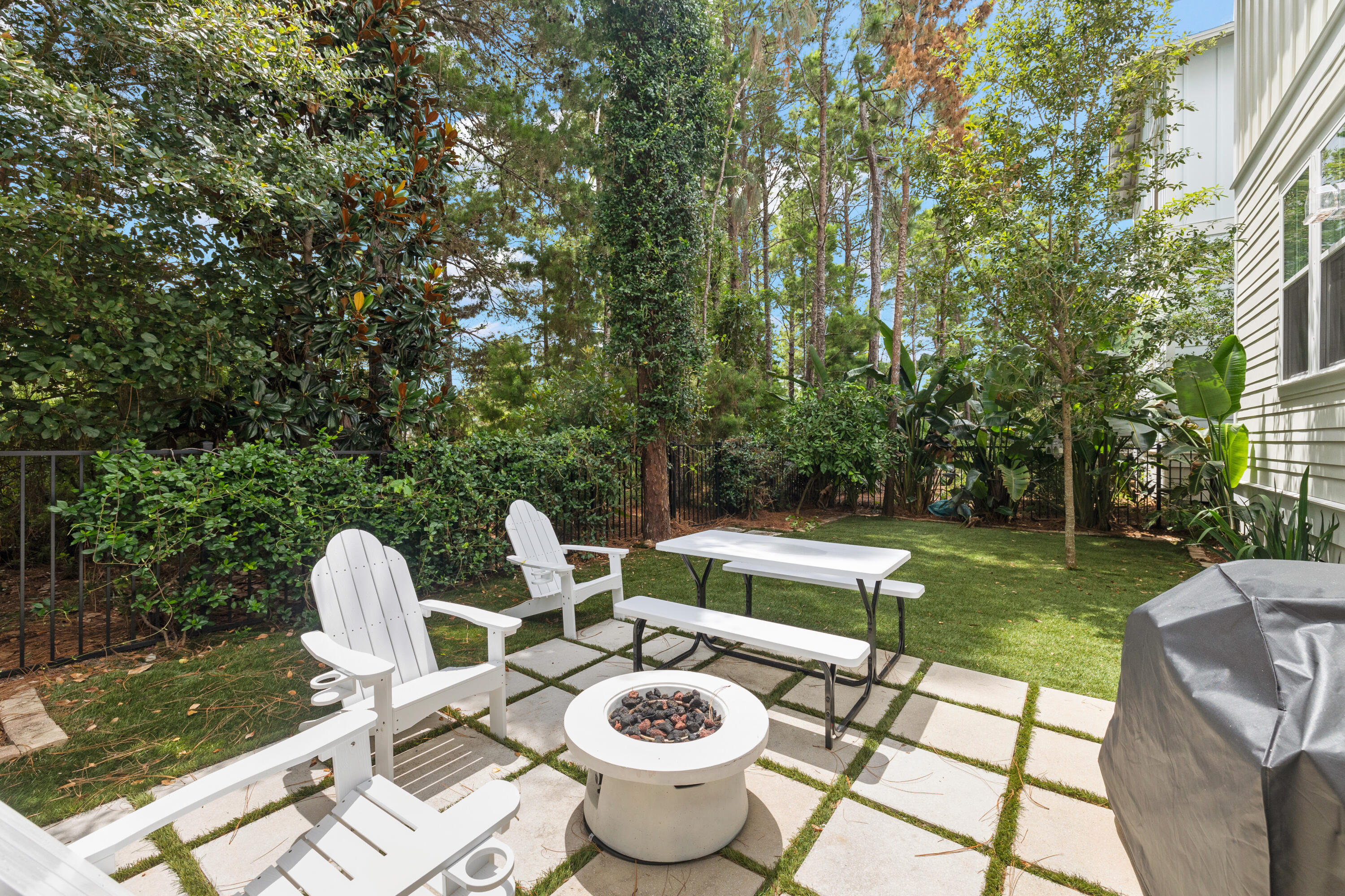 267 Emerald Beach Circle Santa Rosa Beach, FL 32459 - Photo 48 of 59 a view of a backyard with table and chairs potted plants and a palm tree