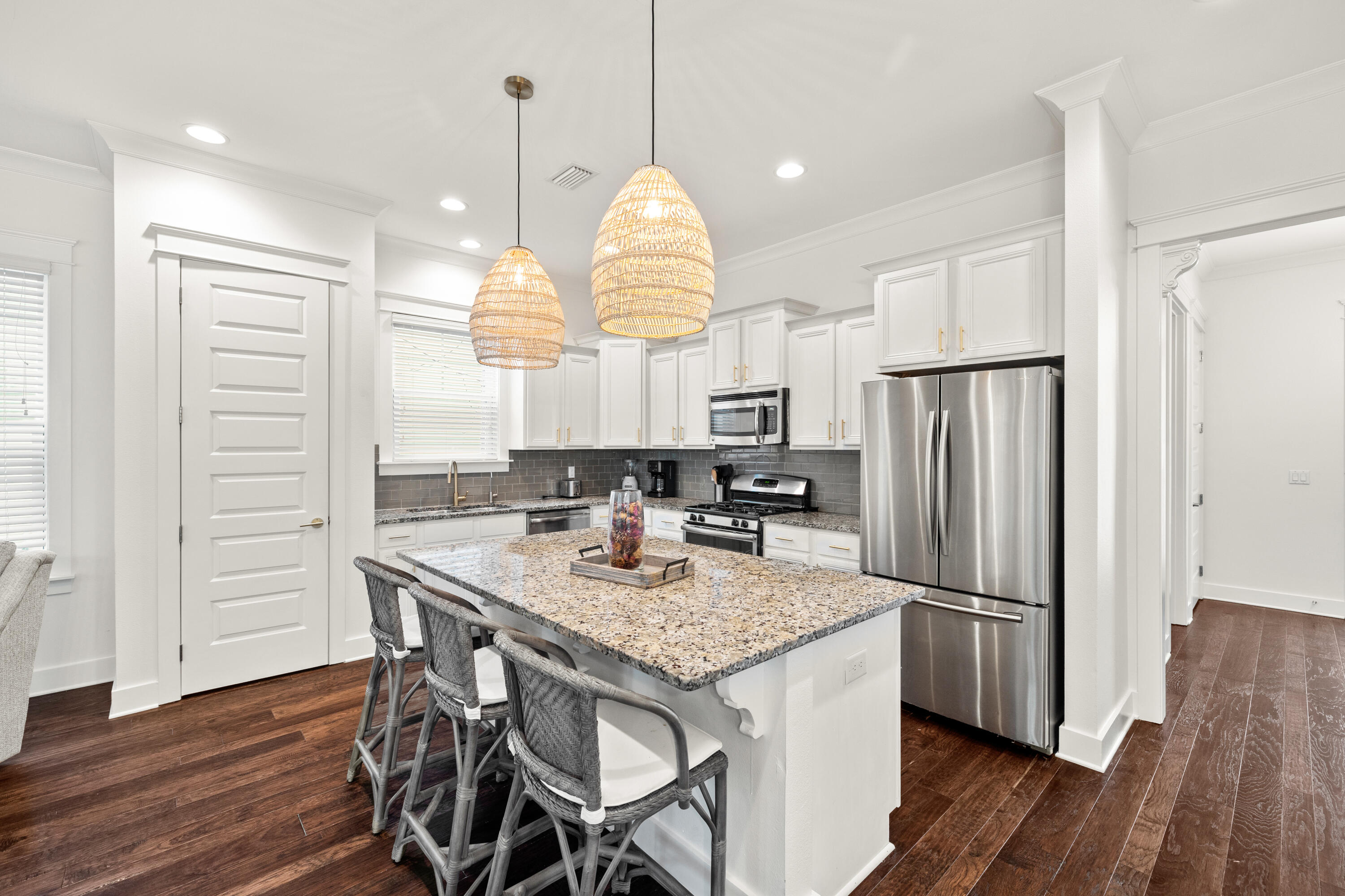 267 Emerald Beach Circle Santa Rosa Beach, FL 32459 - Photo 9 of 59 a kitchen with stainless steel appliances granite countertop a refrigerator a sink dishwasher a dining table and chairs with wooden floor