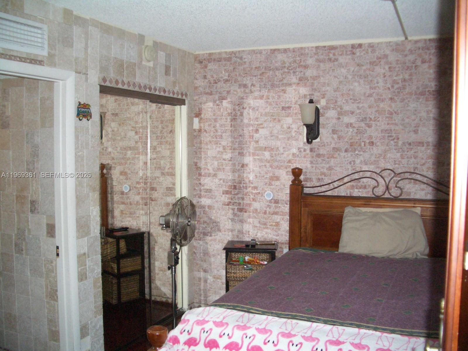 10900 Southwest 104th Street, Unit 324 Miami, FL 33176 - Photo 29 of 34 a bedroom with a bed and a chandelier