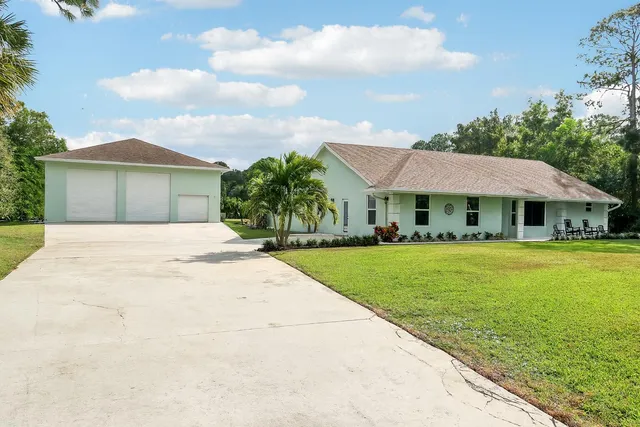 a front view of a house with yard and green space