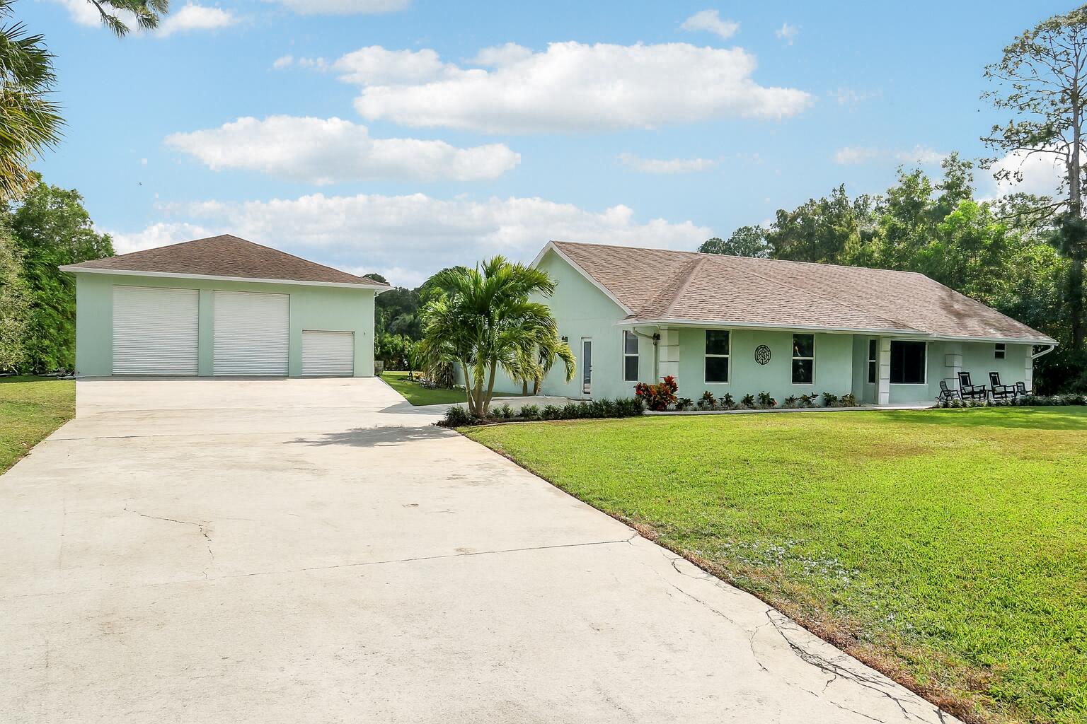 a front view of a house with yard and green space