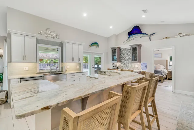 a kitchen with granite countertop a sink stainless steel appliances and white cabinets
