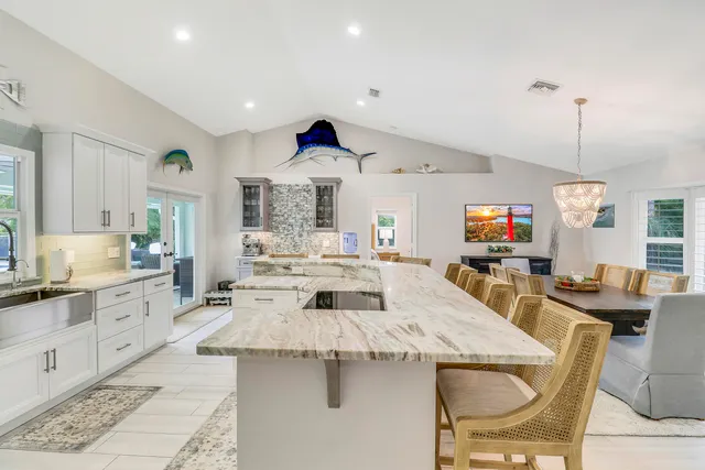 a large kitchen with granite countertop a sink and cabinets