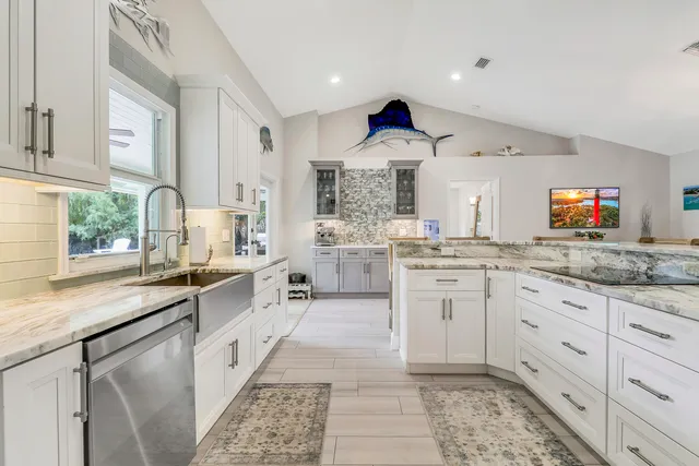 a kitchen with granite countertop kitchen island stainless steel appliances a sink and counter space