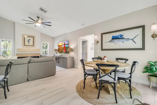 a living room with furniture a rug and a ceiling fan