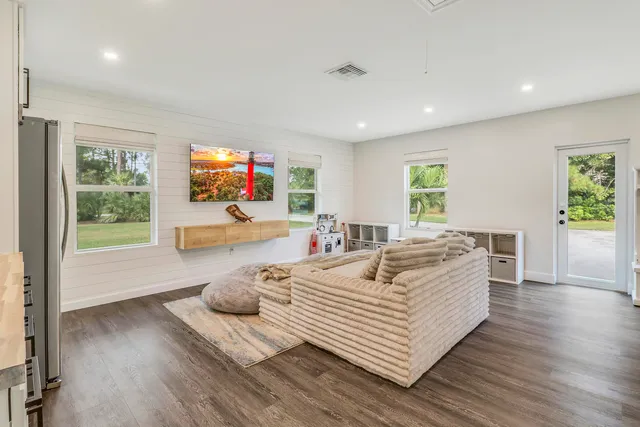 a living room with furniture and a refrigerator