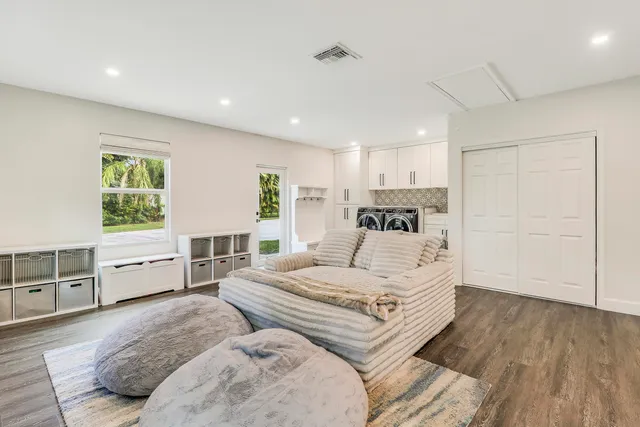 a view of a patio with table and chairs potted plants and large tree