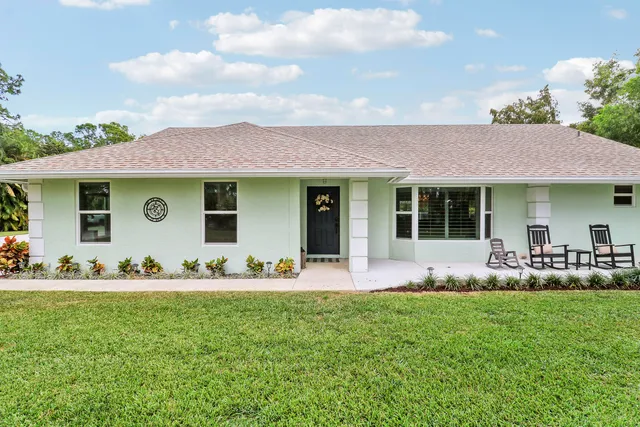 a front view of house with a garden and patio