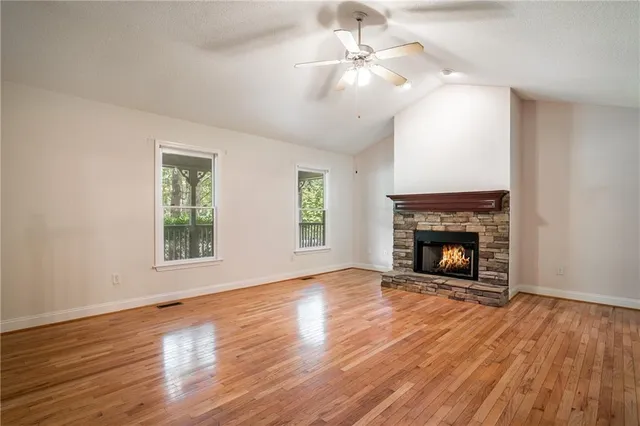 a view of a livingroom with wooden floor and a fireplace