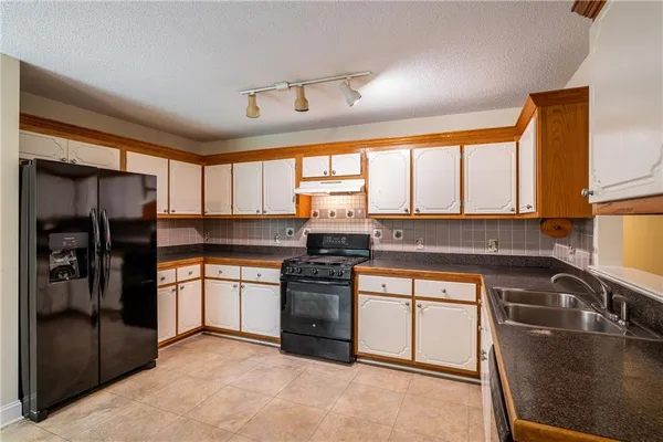 a kitchen with a sink stove top oven and cabinets