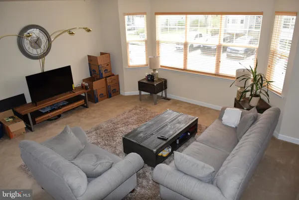 a living room with furniture a window and a flat screen tv