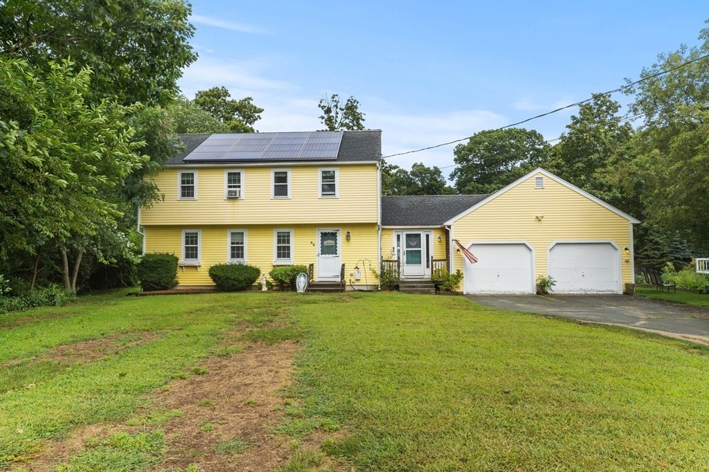 a view of a house with a yard and sitting area