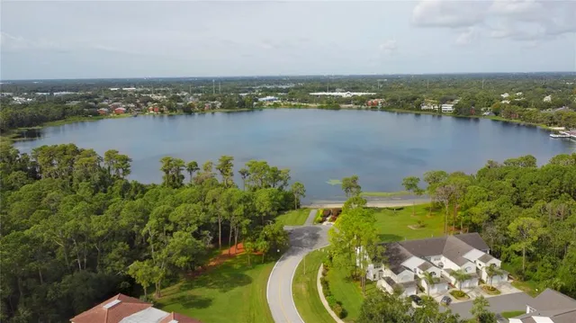 an aerial view of residential houses with outdoor space and lake view