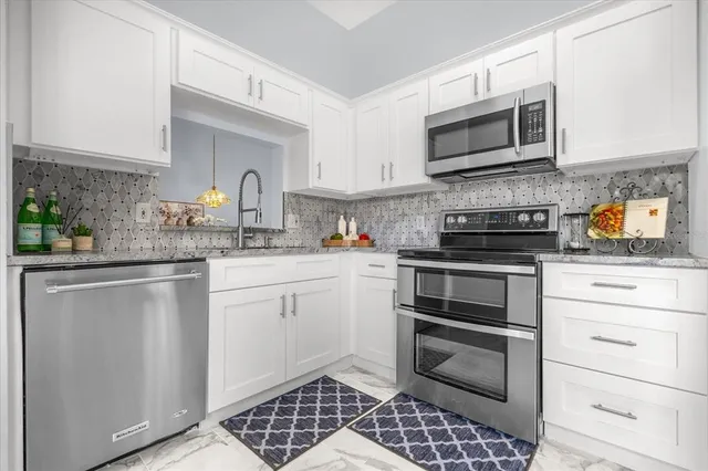 a kitchen with stainless steel appliances a stove microwave and sink