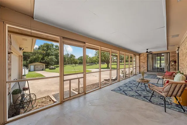 a living room with furniture and floor to ceiling windows