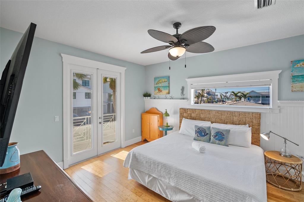 204 66th Street Holmes Beach, FL 34217 - Photo 15 of 53 a bedroom with a bed and wooden floor