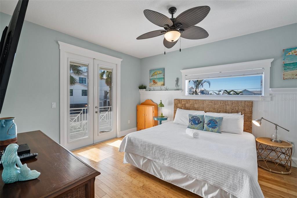204 66th Street Holmes Beach, FL 34217 - Photo 16 of 53 a bedroom with a large bed and a chandelier